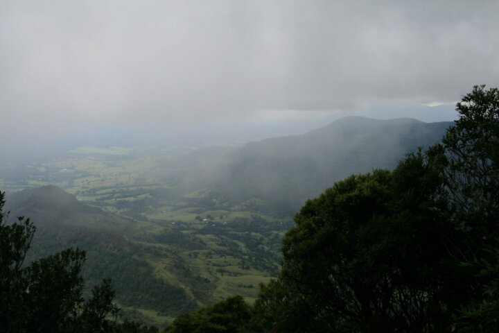 View over valley to distant mountain, shrouded in fog.