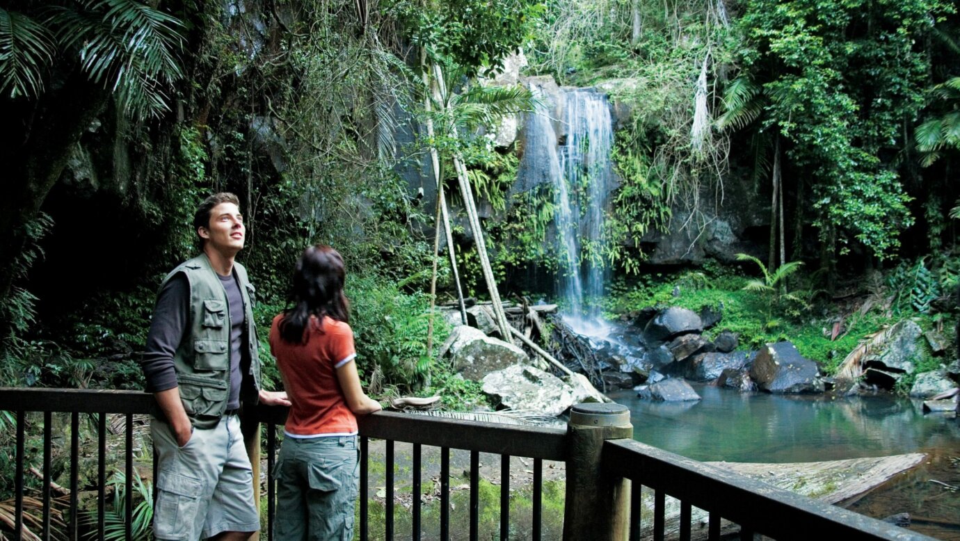 Couple standing on viewing deck with falls in background.