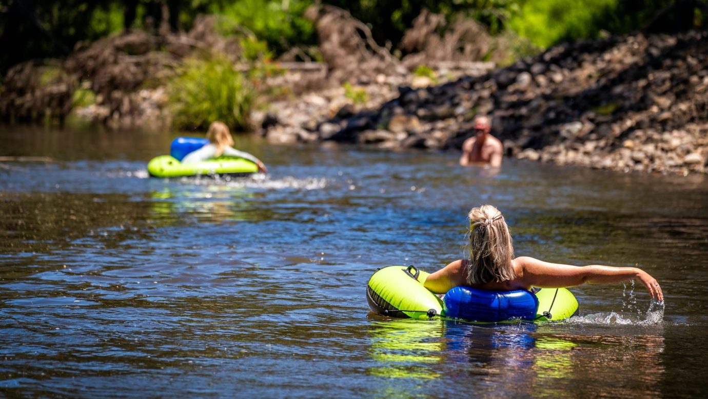 Cool swimming hole in the Albert Riverwith people swimming on floaty toys.