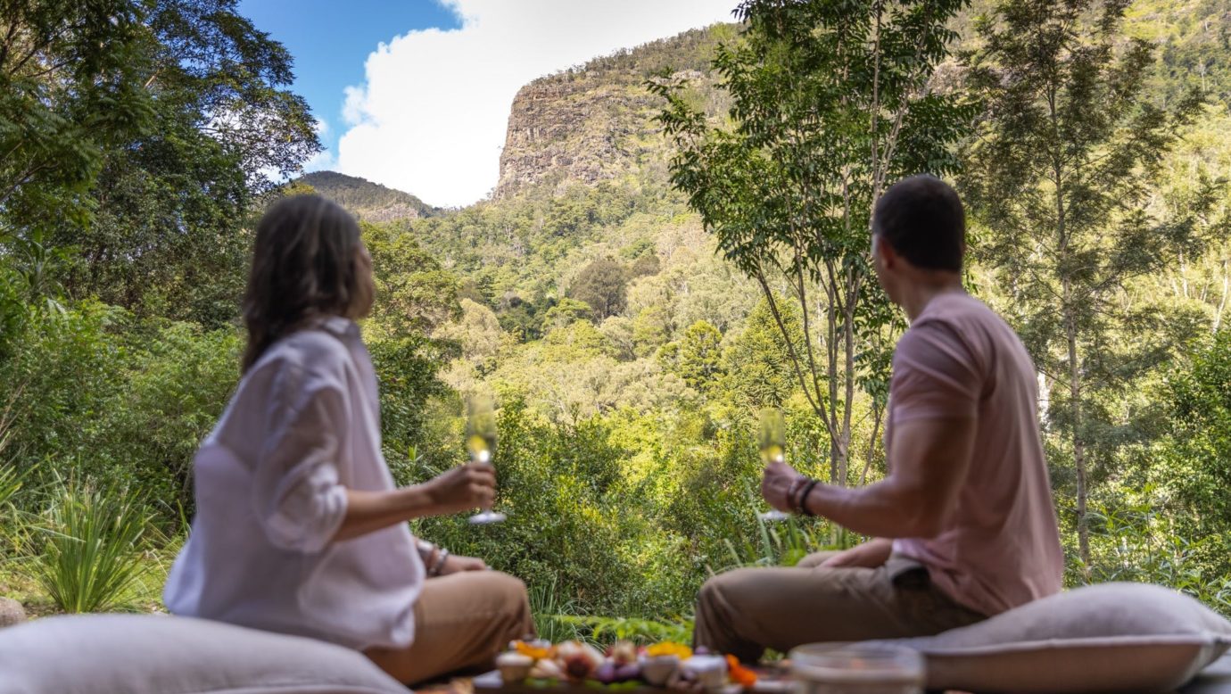 Couple enjoying a welcome platter with a glass of Australian sparkling on the front deck.