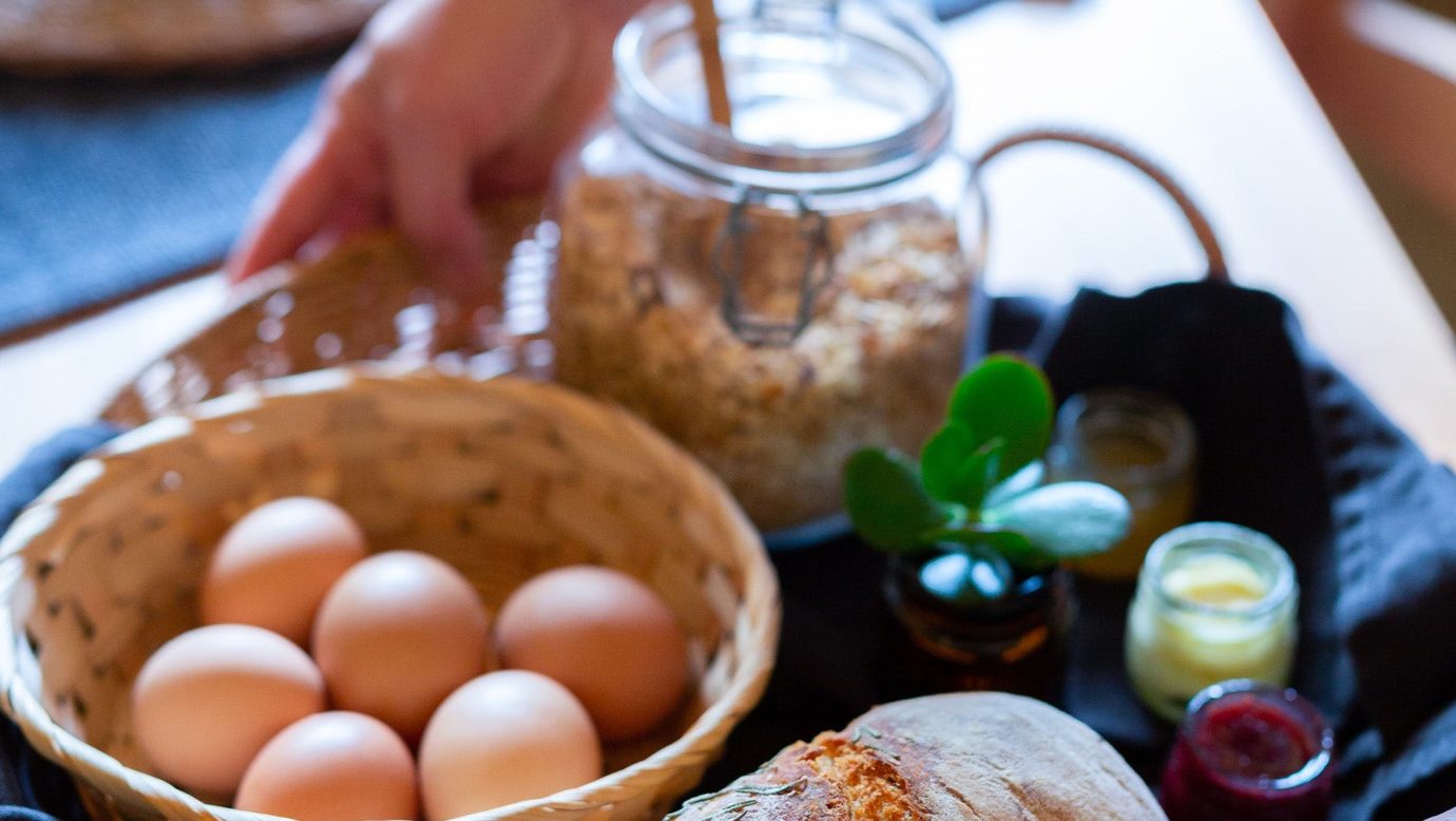 breakfast basket with sourdough, eggs, granola + jams