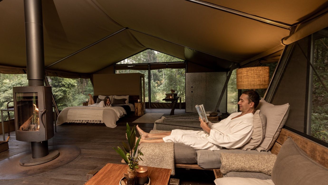 Guest couple relaxing inside safari tent accomodation.