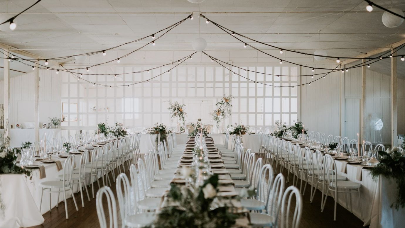 Long dining tables, white wedding tables settings with flowers.