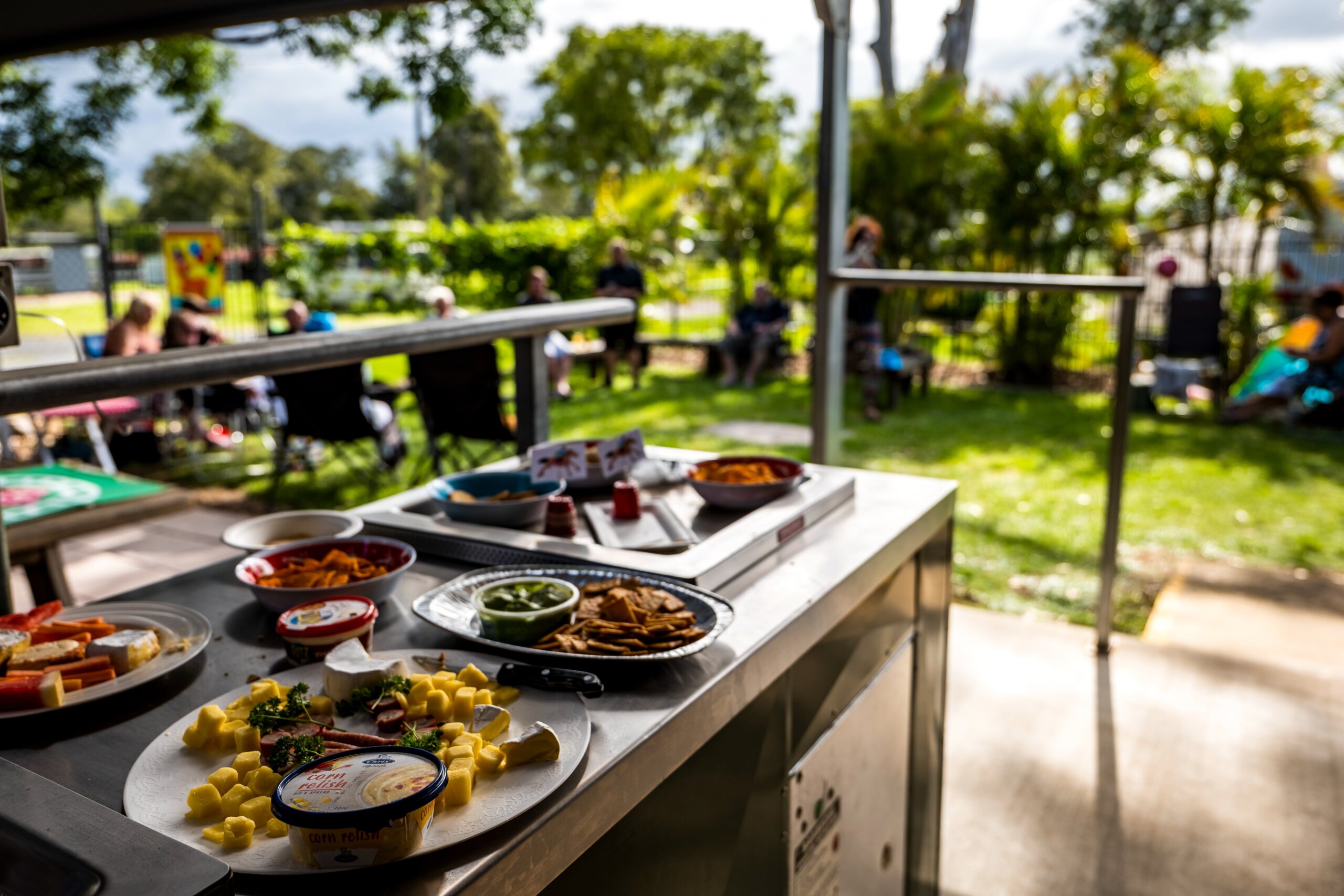 Our camp kitchen dining areas hosting an event, with food platters and our park guests chatting.