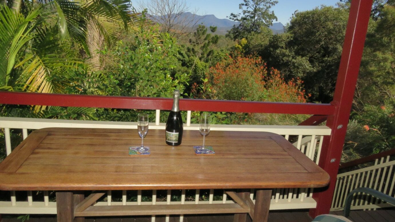 Cottage Verandah with view through gardens to mountains