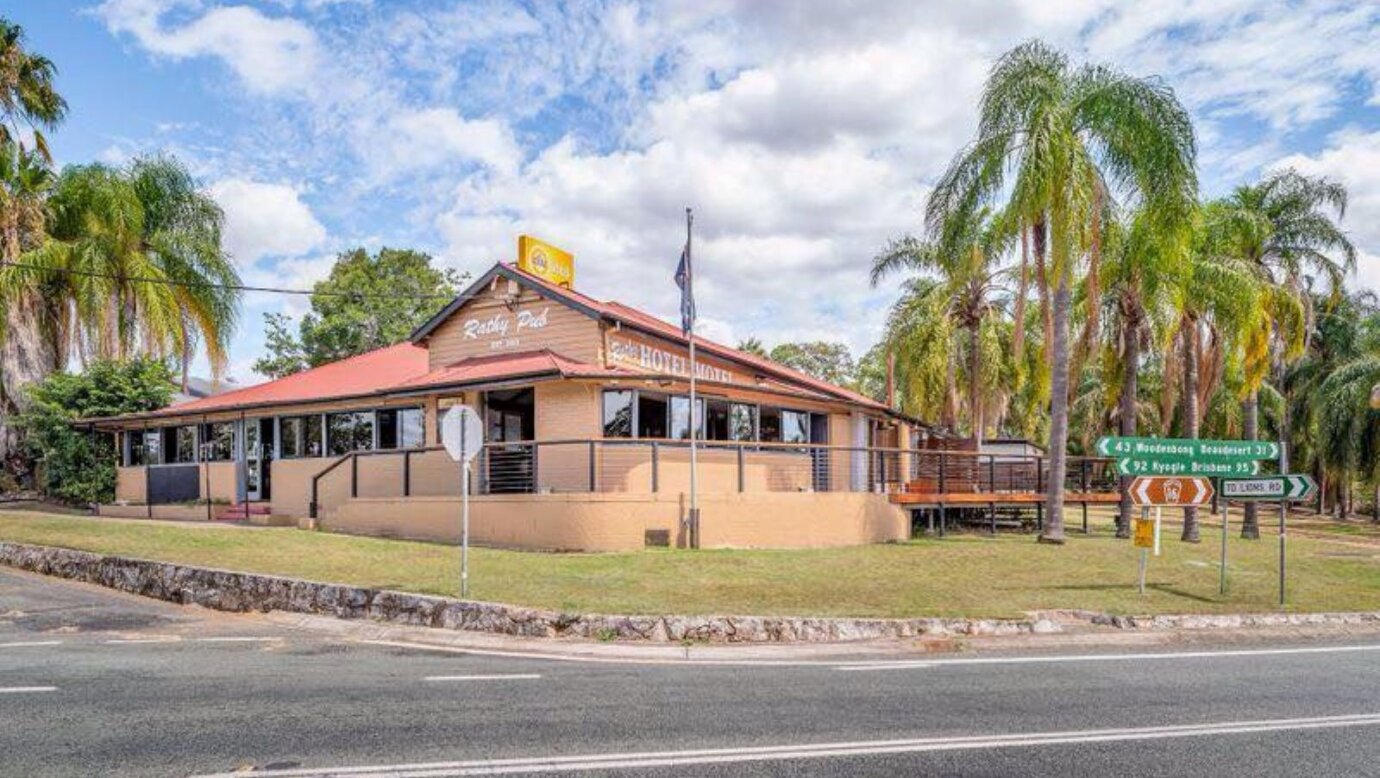 Exterior of a heritage pub surrounded by palm trees