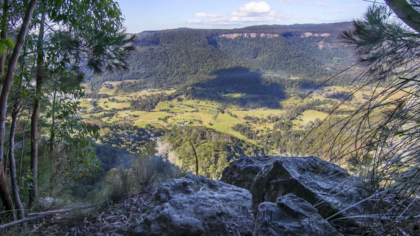 The view of a valley of farmland and Australian forest