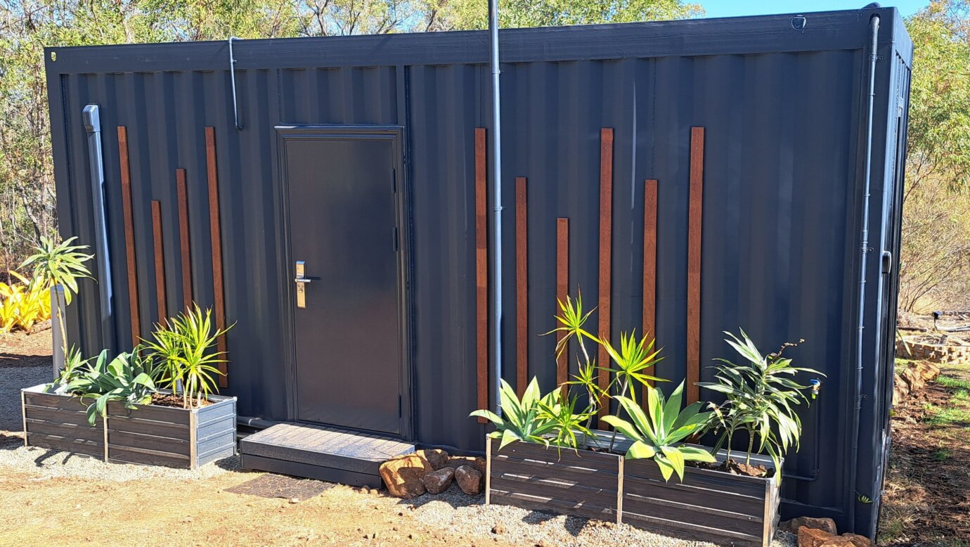 The exterior of the Moogie Pod container, with planter beds and door inside