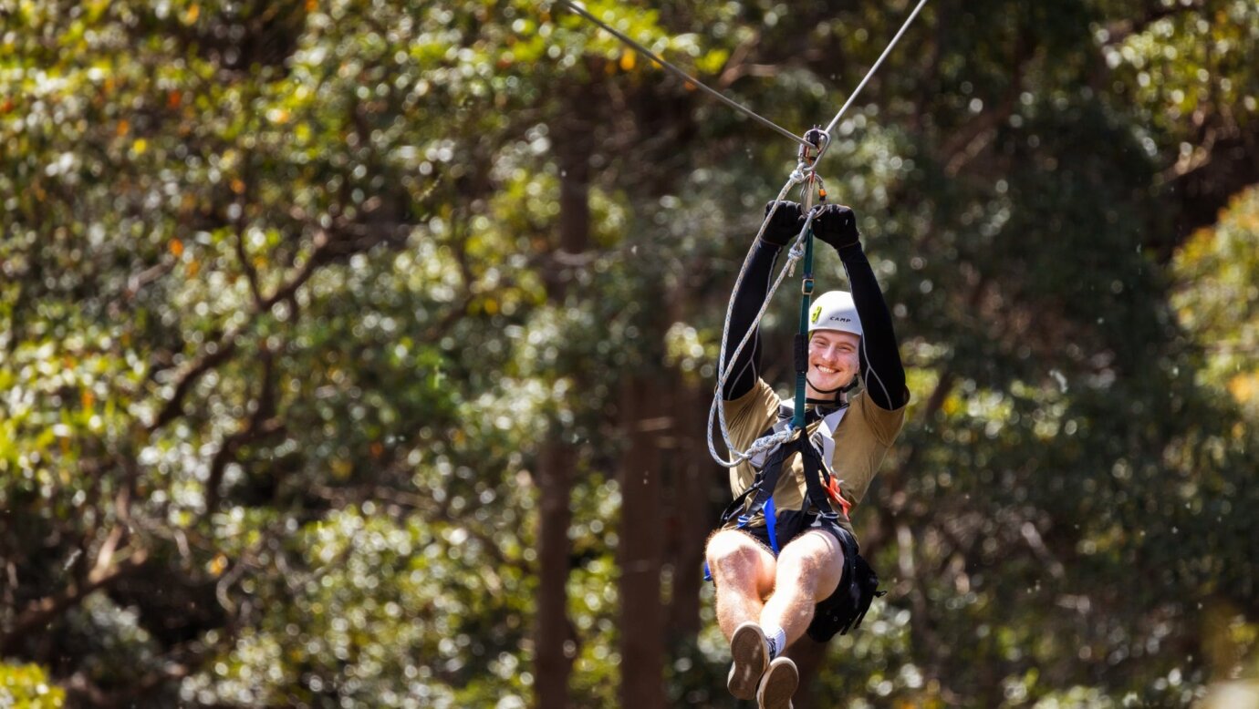 Man smiling doing a zipline