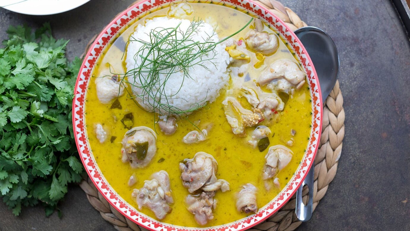 A bowl of green chicken curry with rice