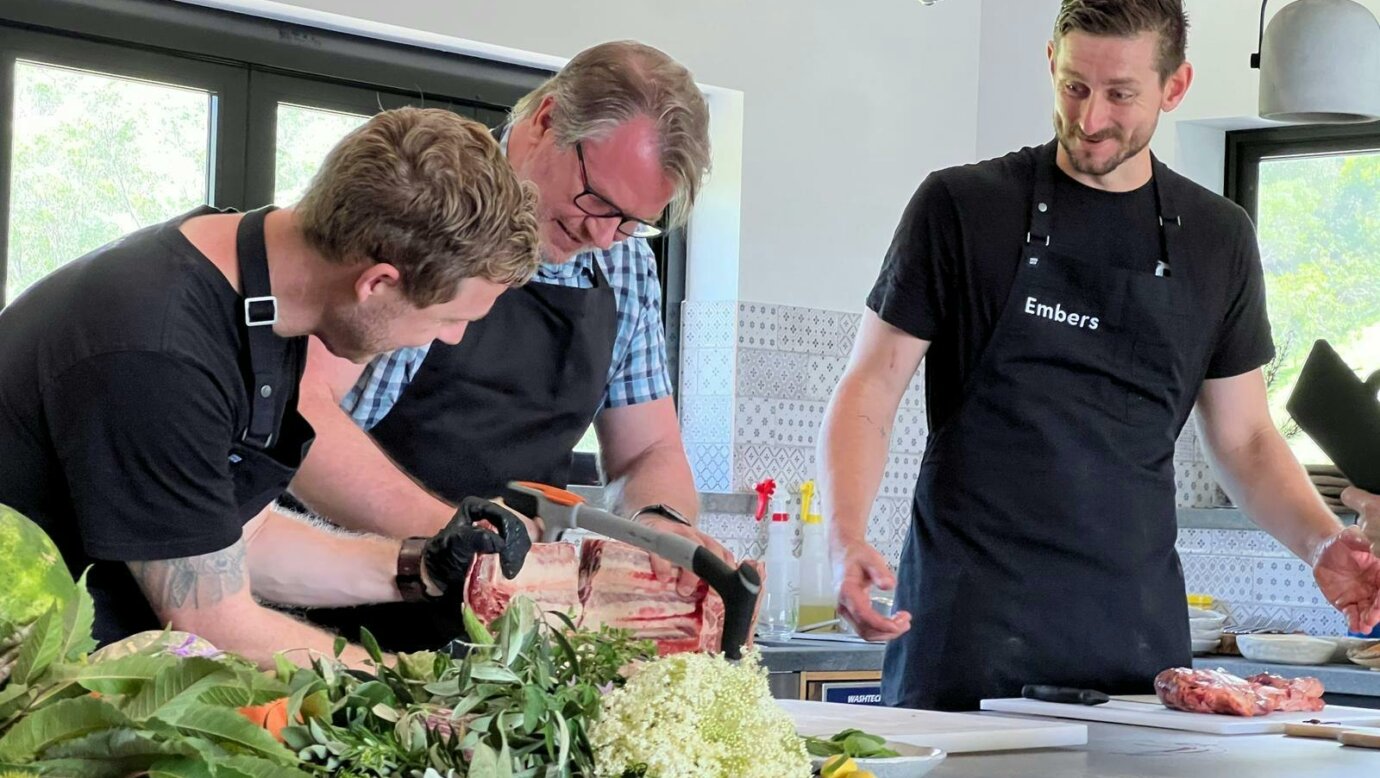 Chefs Simon Furley and Kyle McNamara guiding a participant during a Beef and Fire Masterclass