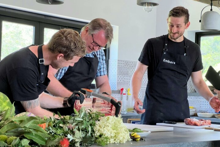 Chefs Simon Furley and Kyle McNamara guiding a participant during a Beef and Fire Masterclass