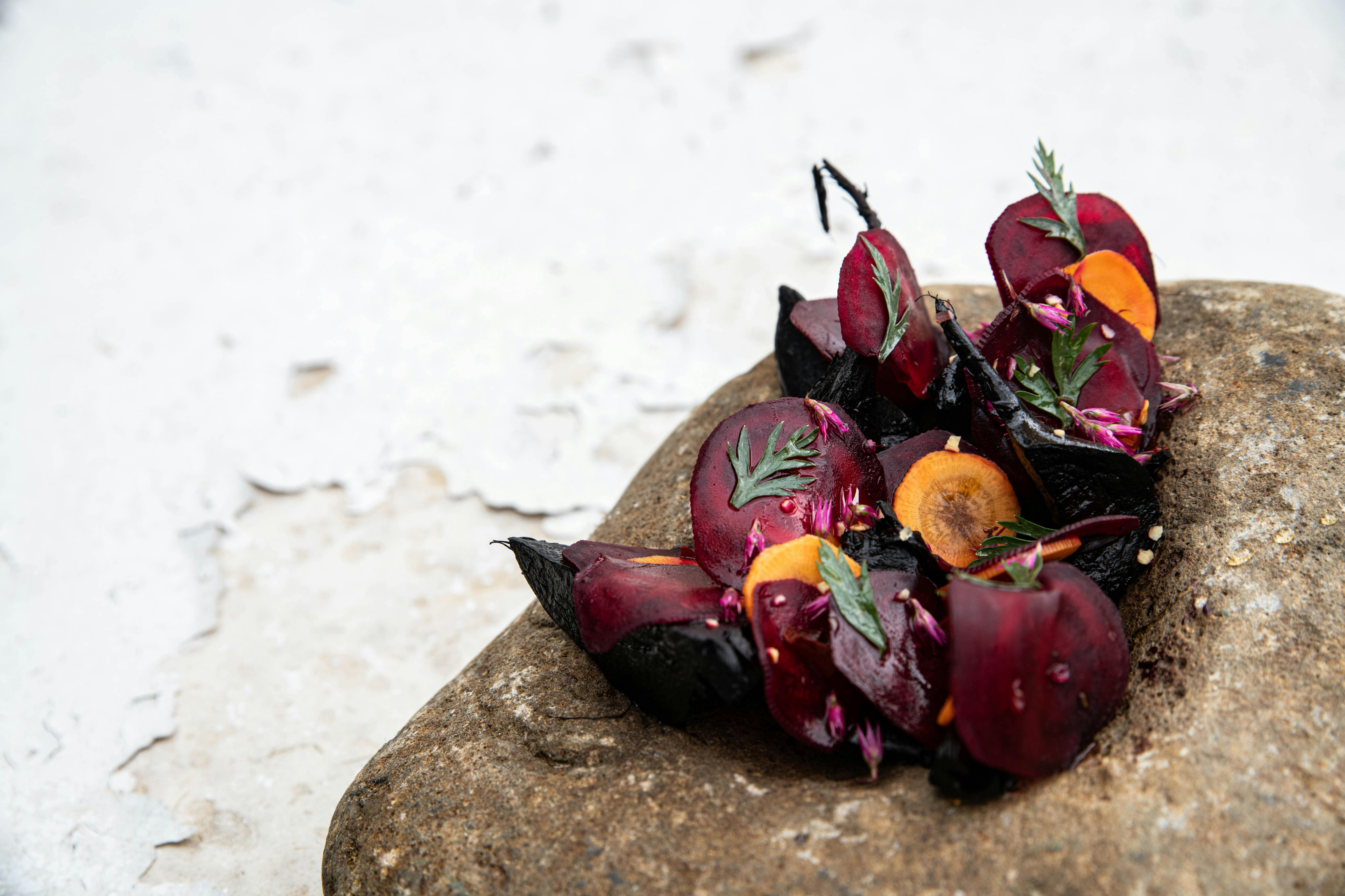 Smoked beetroot and pickled carrot salad served on a river rock