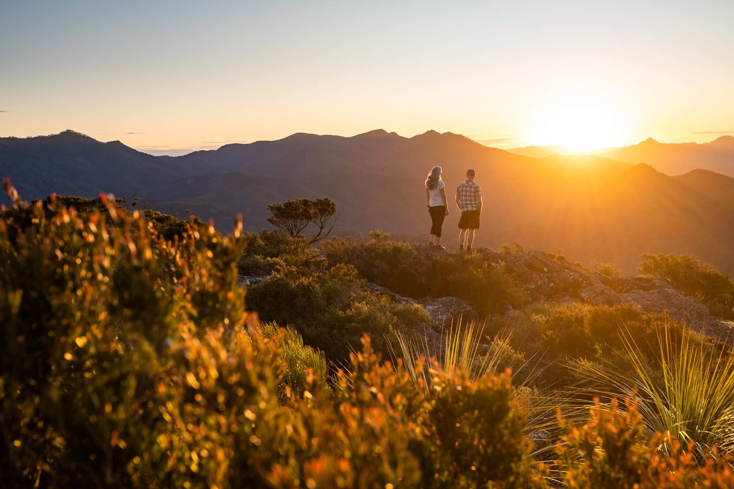 Hikers admiring the surrounding mountains from the top of Mount Maroon in the Scenic Rim, Queensland, Australia