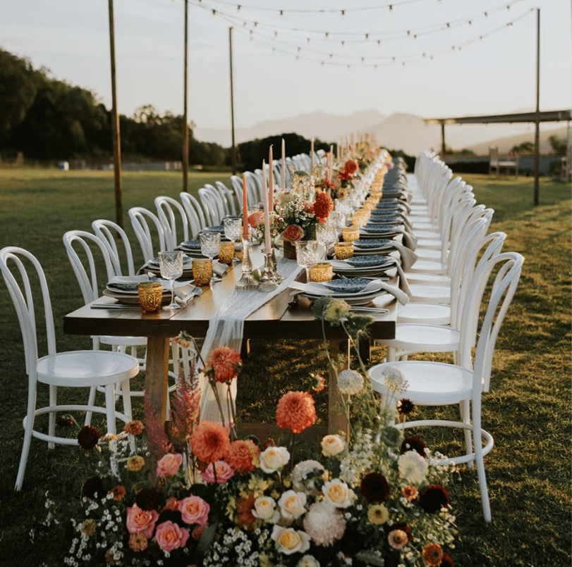 Wedding reception setting at Mount French Lodge under fairy lights with fresh cut flowers.