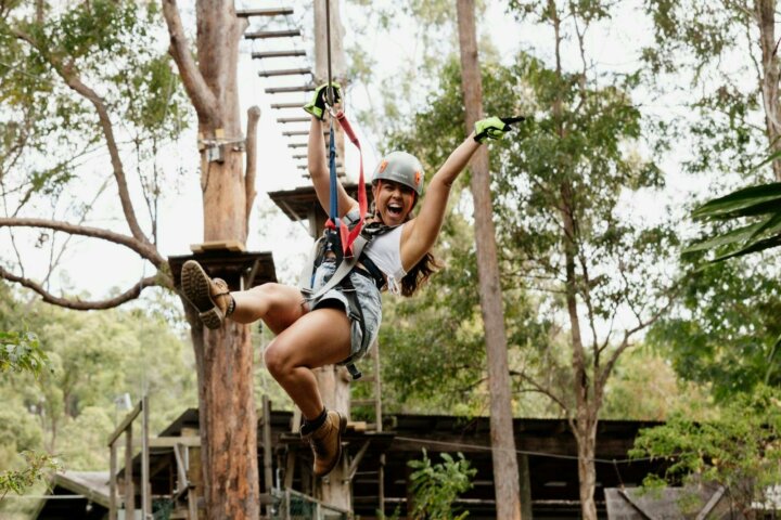 Woman excitedly ziplining down the zipline
