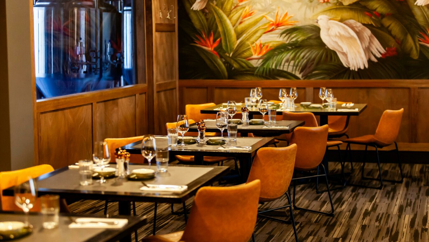 A dining room with brown leather chairs and grey tables
