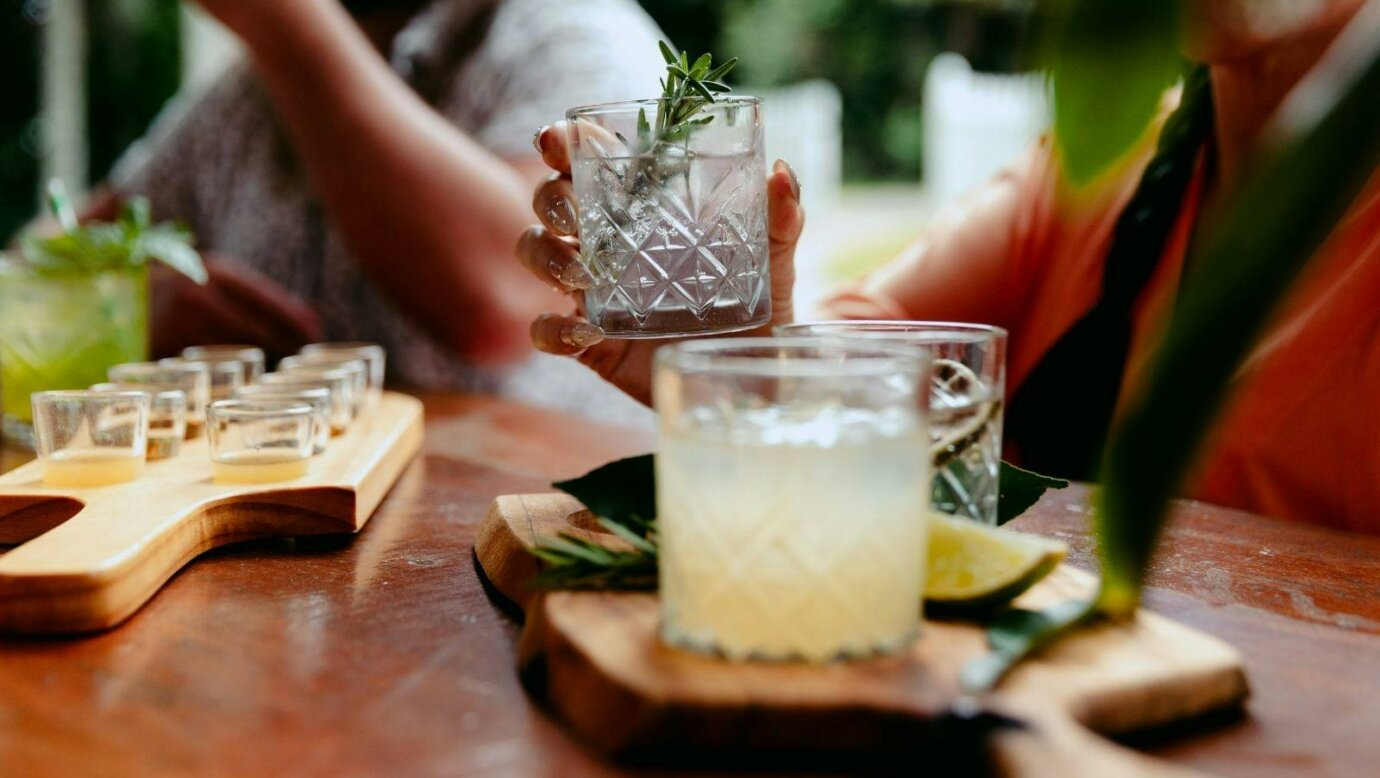 Guests seated at a tasting bench enjoying a guided gin tasting at Tamborine Mountain Distillery, sam