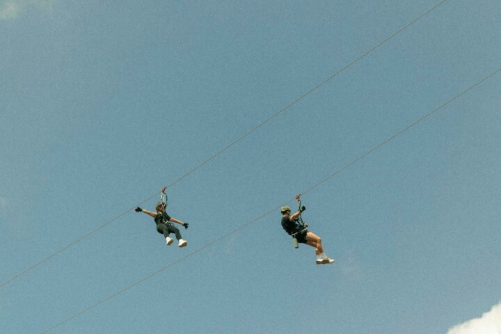 Image of two adventurers ziplining in the overhang tour