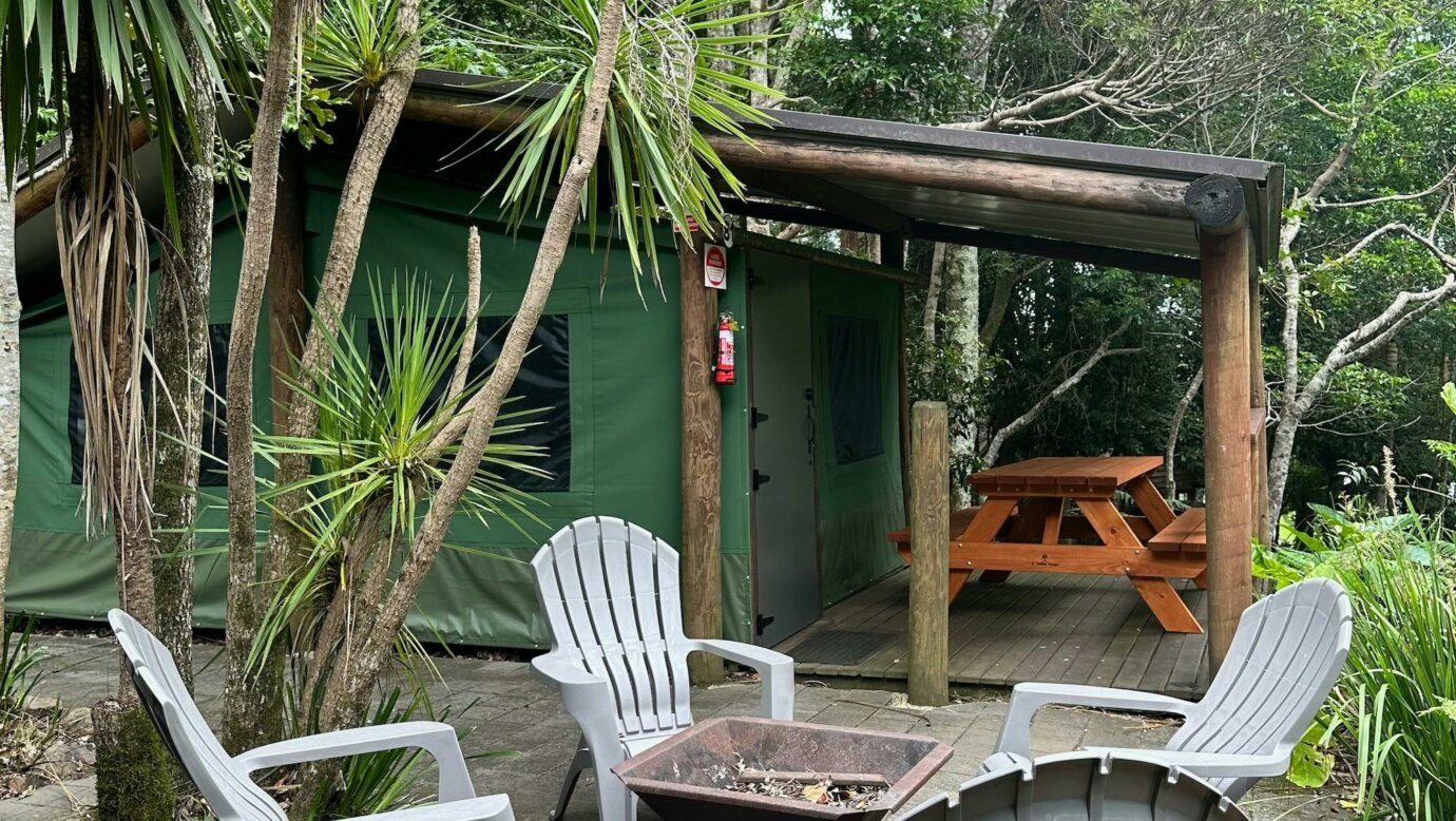 Image shows the exterior courtyard and fire pit of the Safari Tents