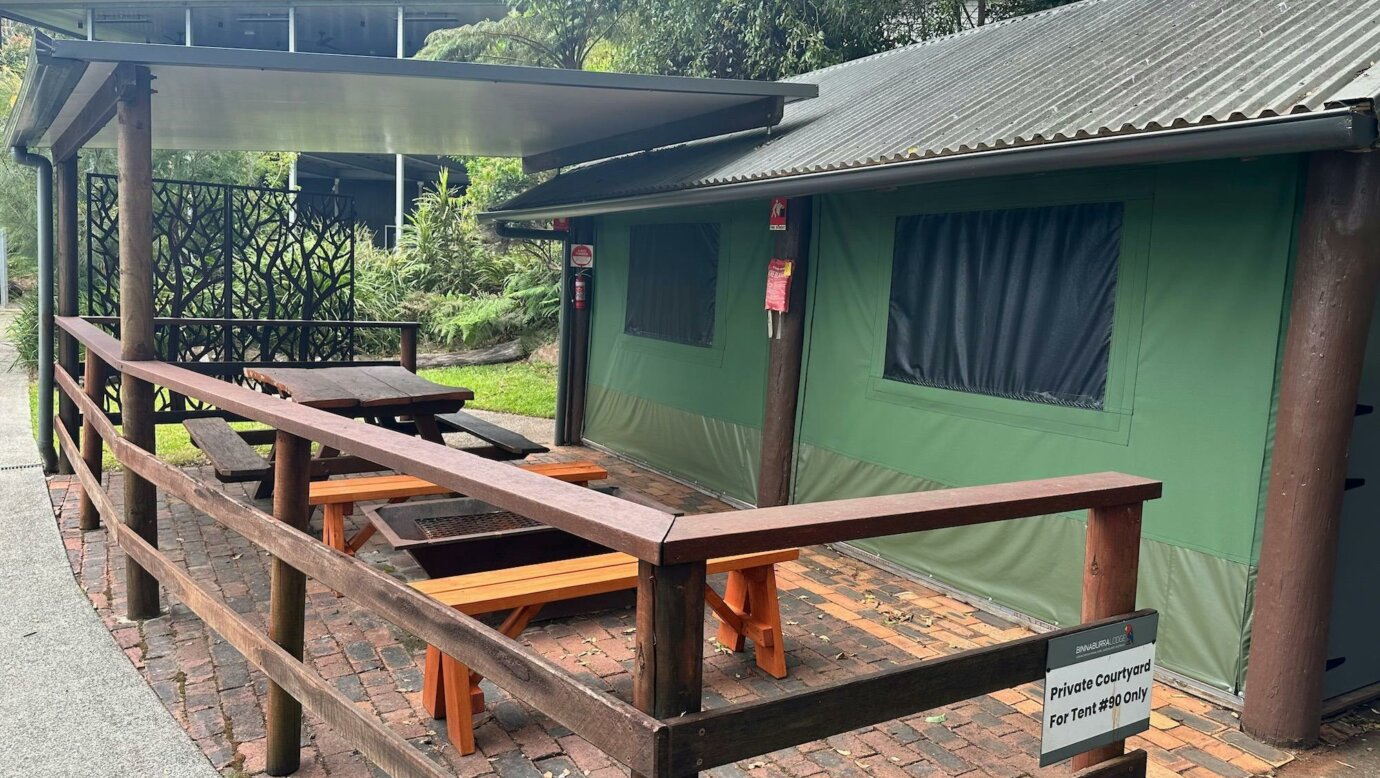 Image shows the exterior courtyard and fire pit of the Safari Tents