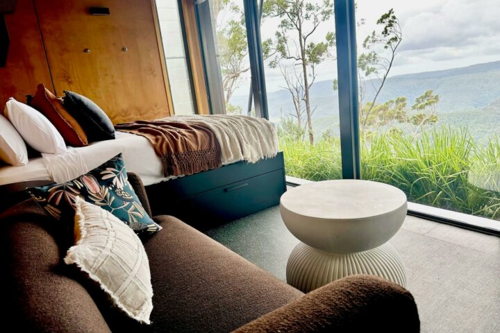 Images shows the interior of a Tiny Wild House,  bedroom area and spectacular views at Binna Burra