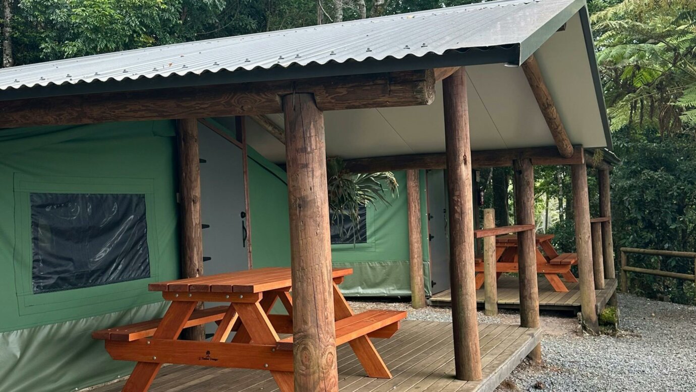 Image shows the exterior courtyard and fire pit of the Safari Tents