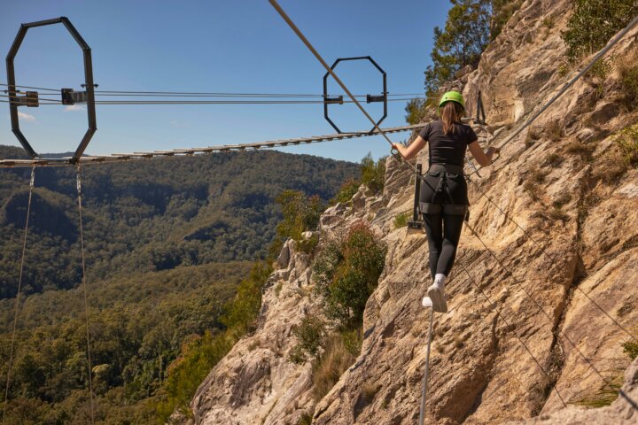 Woman walking across Via Ferrata at Happitat Adventure Park