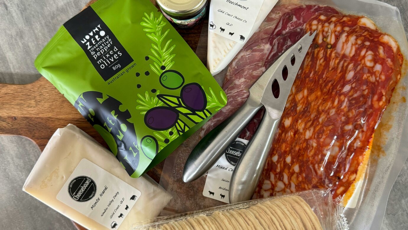 Build your own cheese board options on board, birds eye view. Cheese, meats, olives, jam and cracker