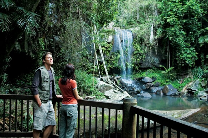 Couple standing on viewing deck with falls in background.