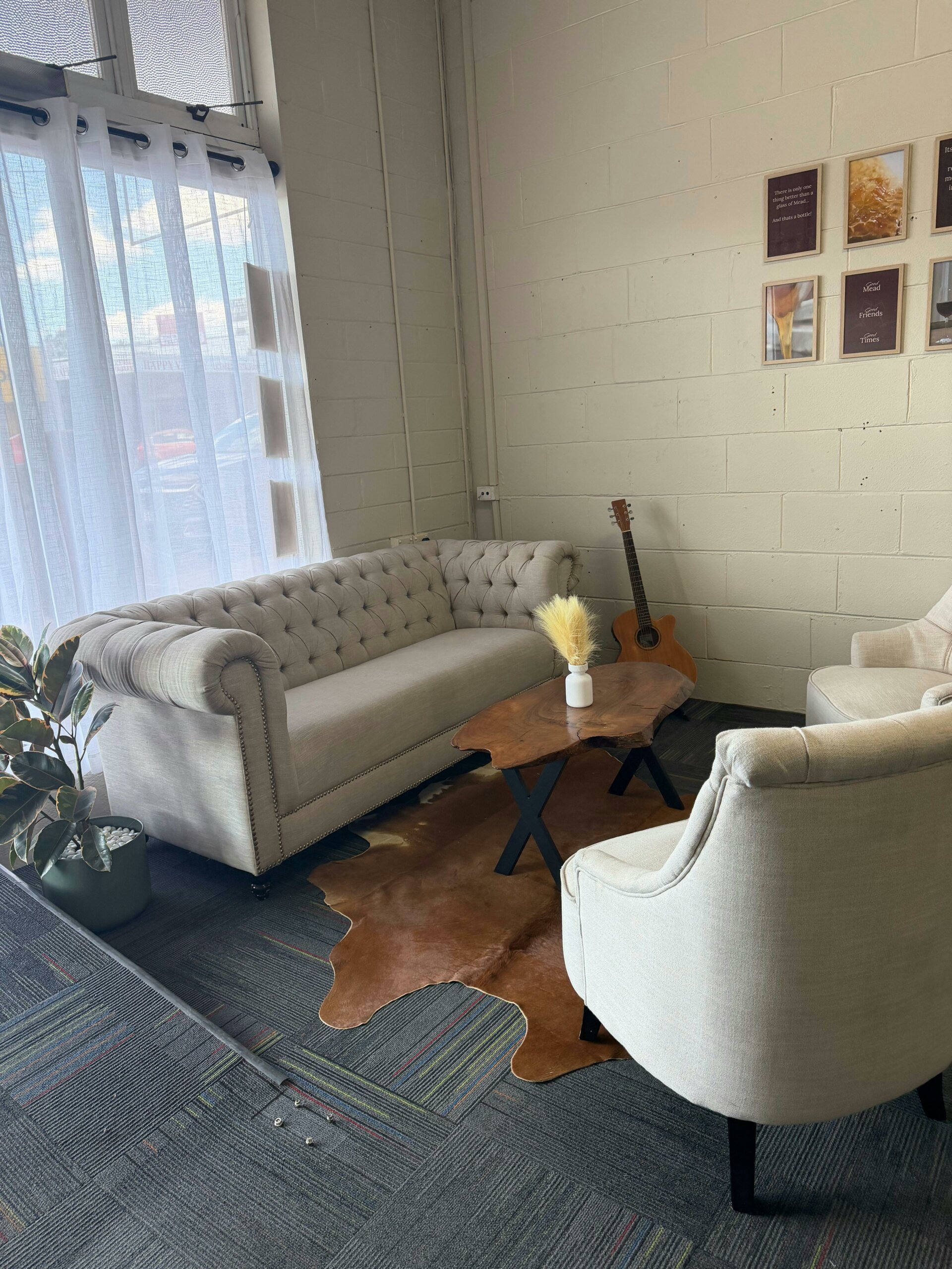 Lounge area for extra comfort in the tasting room. Cow hide rug, chesterfield couch and arm chairs.